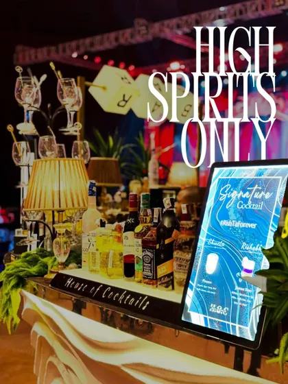Keeping the spirits high with a custom bar design. This setup includes a personalized digital menu with the couple's hashtag, premium liquor display, and unique glassware arrangements.