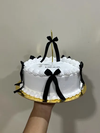A chic vintage cake decorated with black ribbons and bows for a modern, contrasting look.
