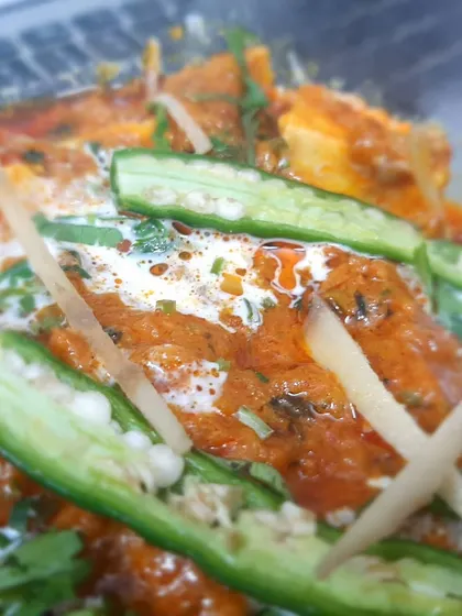 A detailed shot of our Paneer Lababdar, highlighting the creamy gravy and the fresh green chilli and ginger garnish.