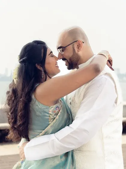 An intimate embrace by the sea, with the Mumbai skyline faintly visible. This photo captures the essence of urban romance.