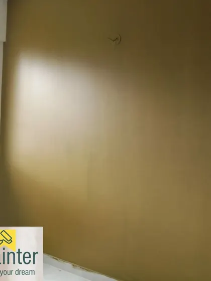 A wall painted in a solid mustard or ochre color, providing a warm and earthy tone.