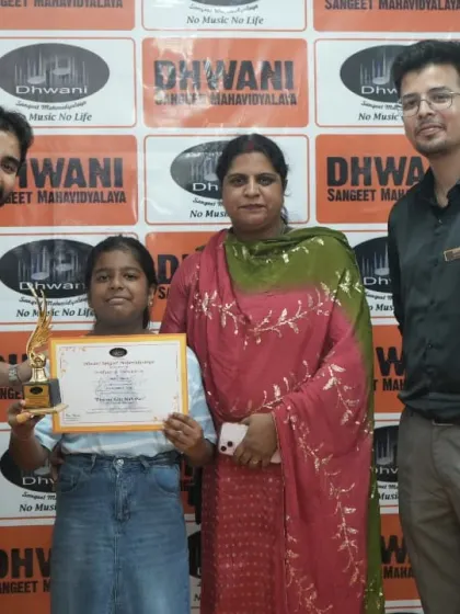 A student with her mother and teacher, celebrating her award.