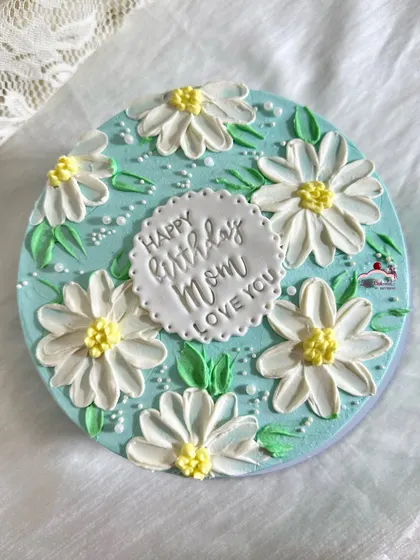 Pretty daisy florals for a mom's birthday. I used a palette knife to create these textured buttercream flowers on a lovely light blue cake.