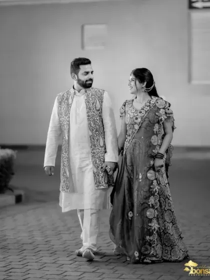A romantic black and white walking shot of the couple during their Mehndi celebration.