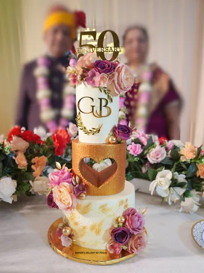 A 50th anniversary is a golden milestone that deserves a truly grand celebration. I designed this elegant, three-tier eggless cake for my own parents' special day, combining classic white and gold with beautiful floral arrangements to create a timeless centerpiece.