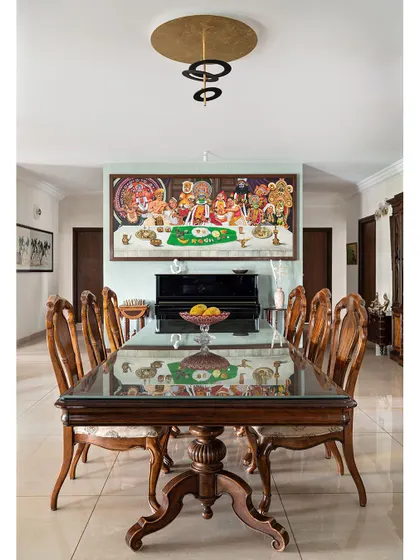The dining area is centered around a magnificent custom painting, 'The Last Sadya,' a creative take on Da Vinci's masterpiece celebrating the dance forms of Kerala.