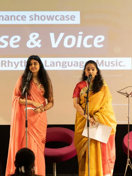 A duo performing a collaborative piece in traditional attire. We celebrate diverse forms of expression, including group performances and multilingual poetry.