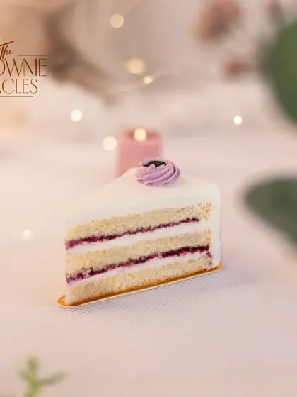 This Lemon Blueberry pastry slice shows the layers of light vanilla sponge and my house-made blueberry filling, topped with a delicate swirl of frosting.