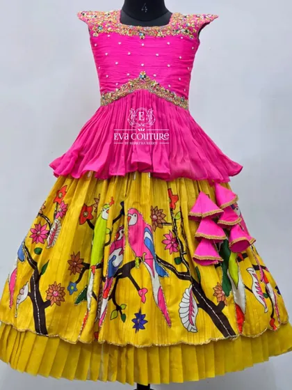 A bright and cheerful layered gown. The pink peplum top is paired with a yellow skirt featuring a colorful parrot print.
