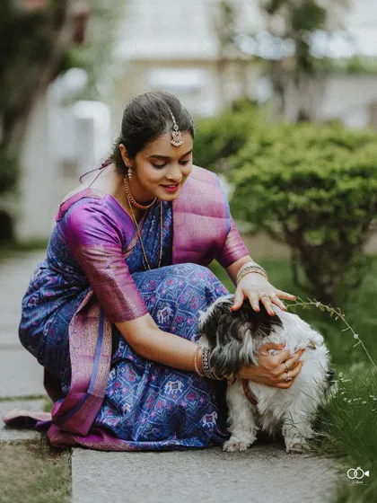 A heartwarming photo of the bride crouching down to pet her adorable dog, a sweet moment of connection.