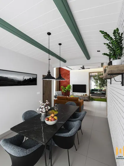 A modern duplex in Calicut with a Scandinavian color palette, featuring a black marble dining table and a striking white brick wall.