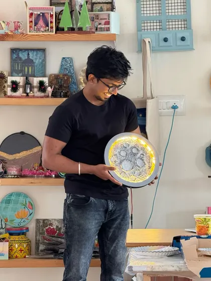 This artist is admiring his handiwork, a beautifully detailed moon lamp. The lighting really brings out the texture and craters.