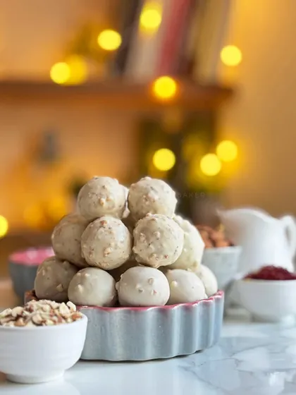 A bowl of my Kesar Tres Leches Truffles, ready to be boxed up for Diwali. The white chocolate shell is studded with nuts, hiding a delicious, saffron-infused, milk-soaked cake center.