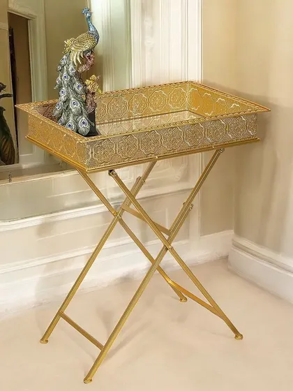 This festive side table features a gold tray top on a foldable X-frame base. It's a glamorous and practical piece, perfect for serving drinks or as a temporary accent table during parties.