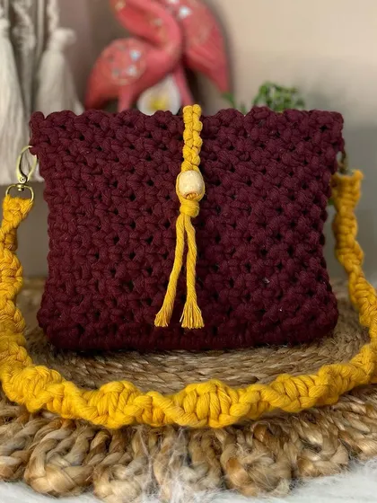 I love this rich color combination of deep maroon and mustard yellow. This crossbody bag is a perfect statement piece, finished with a wooden bead and tassel closure.