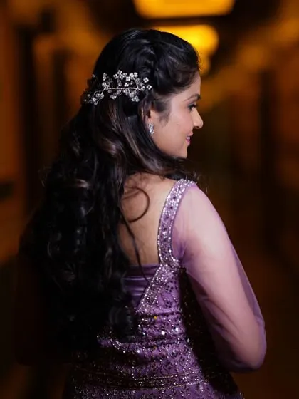 A view of the elegant half-up, half-down hairstyle with a jeweled accessory, perfect for an engagement party.