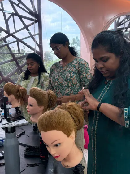 Students practicing advanced hairstyling techniques on mannequins during a professional batch session.