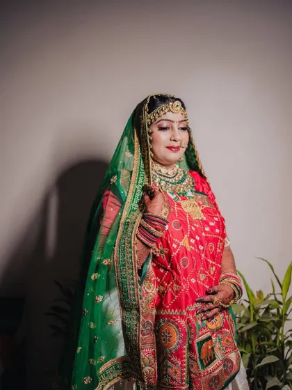 A stunning portrait of the bride, Manali, in her colorful red and green traditional Gujarati wedding attire.