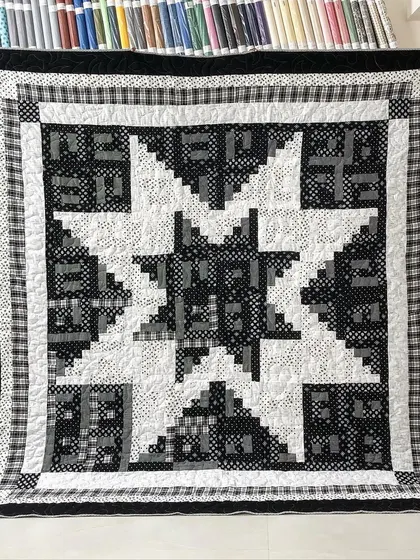A "Log Cabin Star" quilt in a striking black and white color scheme.