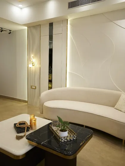 A view of the curved sofa against the textured wall paneling. The subtle play of light and shadow on the wall creates a dynamic effect, making the room feel alive. This is a great example of budget-friendly luxury wall treatment.