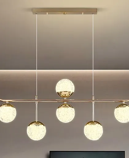 A linear pendant with six textured crystal globes. This light provides ample illumination and a touch of glamour for a dining table or island.