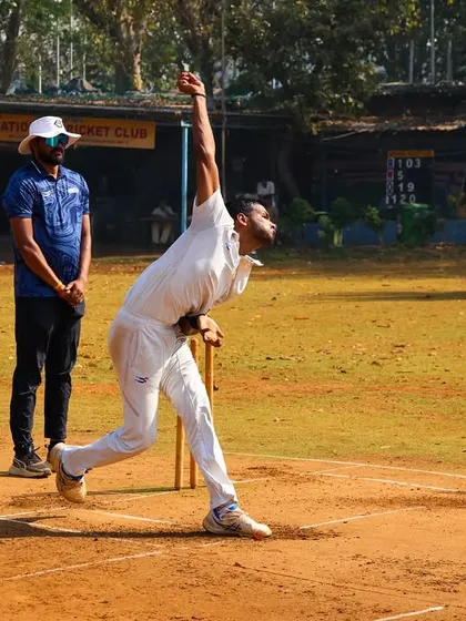 A fast bowler hitting his stride under the watchful eye of our coach during a practice game.