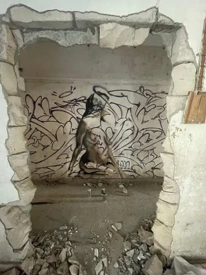 The same piece viewed through a hole in the wall, creating a natural frame for the art.