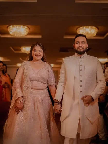 The couple makes their entrance at the engagement party, holding hands and walking confidently towards their future.