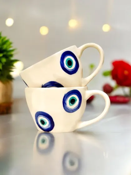 A pair of ceramic cups featuring a hand-painted evil eye design. This set combines modern aesthetics with traditional symbolism, making it a unique Diwali gift.