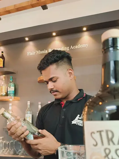 A bartender carefully inspecting a bottle of premium gin, showcasing our team's knowledge and appreciation for quality spirits.