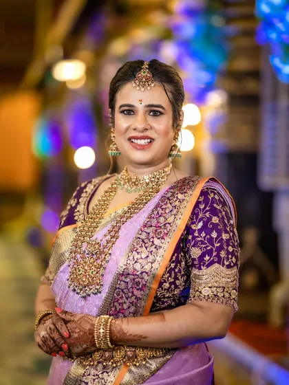 A beautiful portrait of Anusha. The intricate embroidery on her custom purple blouse is clearly visible, showcasing the detailed craftsmanship.
