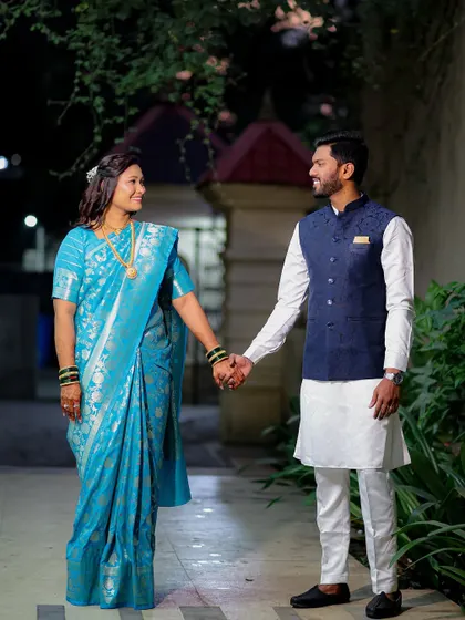 A full-length shot of the couple walking hand-in-hand. This captures their coordinated traditional outfits and the beginning of their journey together.