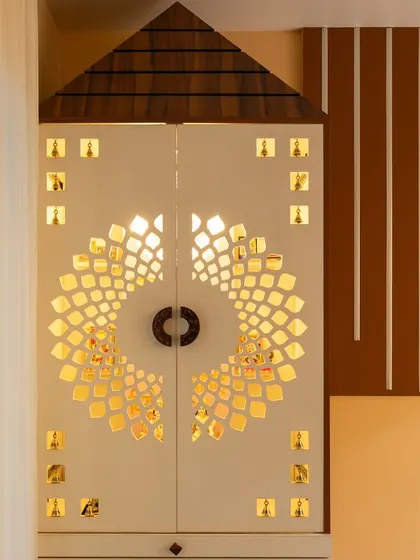 The closed view of the pooja unit, with its beautifully carved jaali doors that allow a glimpse of the light inside.