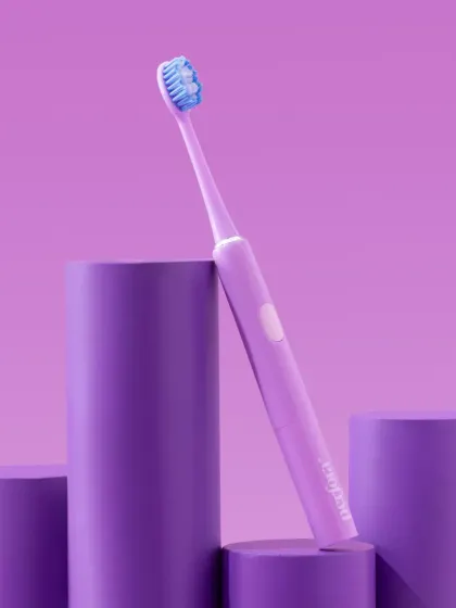 A dynamic shot of a Perfora toothbrush leaning against cylindrical props. The monochromatic purple color scheme creates a bold and artistic image.