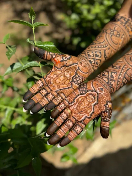 A close up of the Vitthal and Rakhumai portraits. The sunlight beautifully highlights the rich color of the natural henna stain.