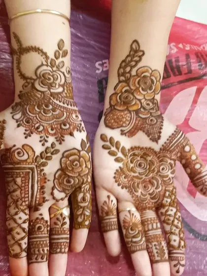 This is a great example of a simple yet elegant party mehendi. The design focuses on a bold rose pattern with leafy vines, perfect for guests at any event.