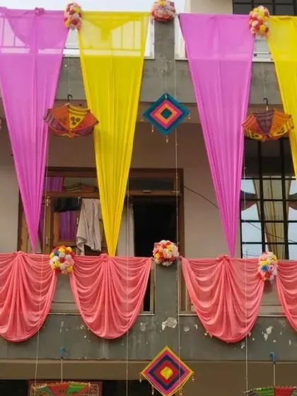 Balcony decoration using pink and yellow drapes with floral bouquets, creating a simple and pretty look.