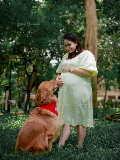 A quiet moment between a mom-to-be and her loyal companion. This outdoor shot beautifully captures the bond they share as they wait for the new family member.