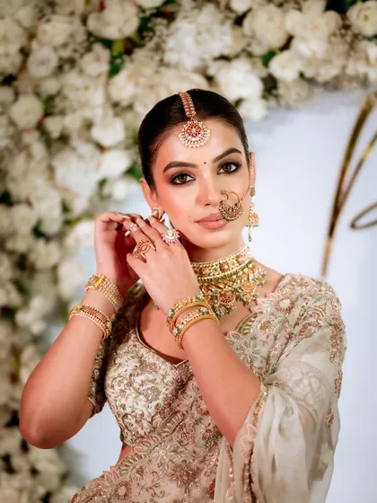 A classic bridal pose, looking directly at the camera. The makeup is confident and beautiful, with a perfect balance of softness and glamour.