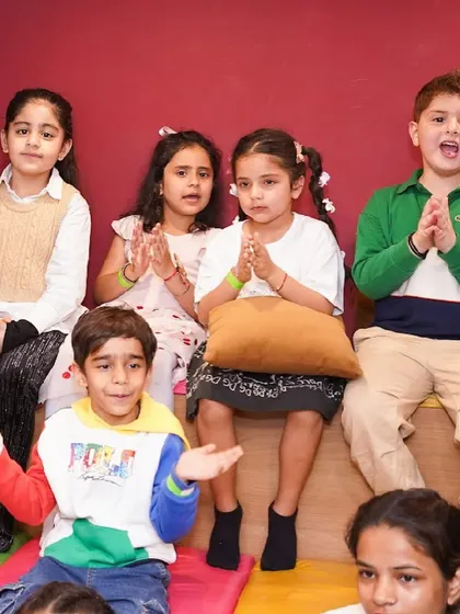 A group of kids clapping and singing along during a party.