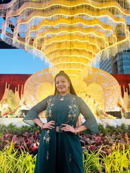 A powerful stance in a chic green embroidered jacket set against a stunning outdoor wedding setup. This outfit is a perfect example of modern fusion wear for an elegant daytime event.