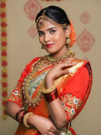 A close-up of the bride, focusing on her happy expression and the intricate details of her makeup and jewelry.