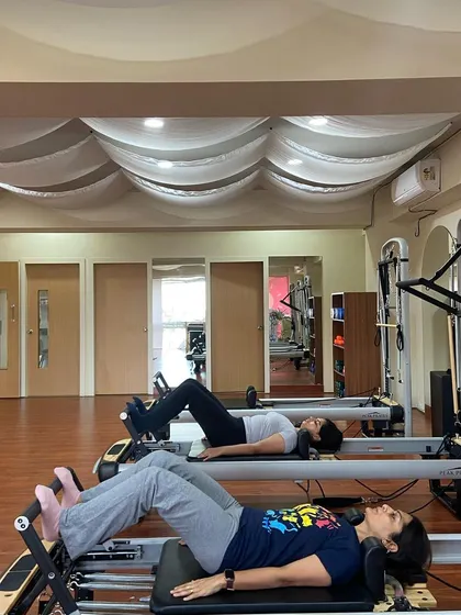 The duo transitions to the reformers for synchronized footwork. Partner sessions are a wonderful way to stay motivated and share a positive fitness experience.