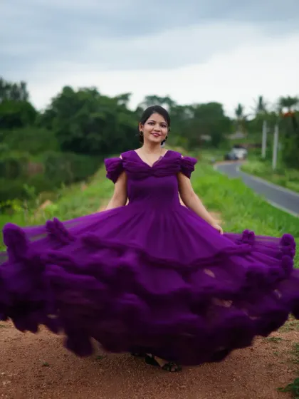 A dramatic and playful shot of a woman twirling in a purple ruffled gown, perfect for capturing movement and joy.