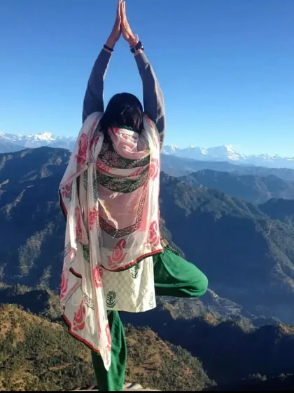 Performing Vrikshasana (Tree Pose) with the majestic snow-capped Himalayan peaks in the distance. Practicing yoga here feels like a direct conversation with nature.