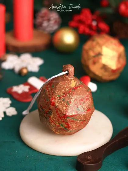 A still life of the edible Christmas ornament chocolate bomb, showcasing its unique, geometric design.