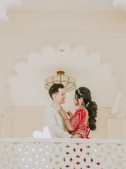 An intimate portrait of Spencer and Namrata framed by the elegant white arches of their palace wedding venue.