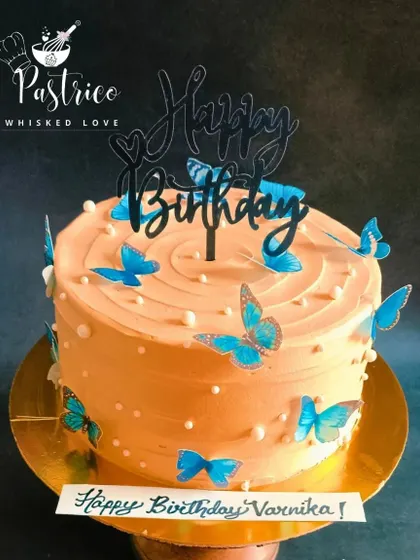 A simple yet beautiful butterfly cake with a soft orange frosting and delicate blue butterflies.