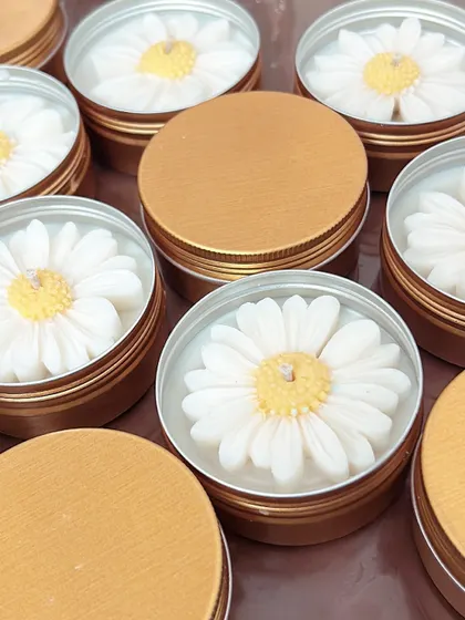A collection of daisy tin candles. The golden tins give them a premium feel, and the daisy on top is just so cheerful.