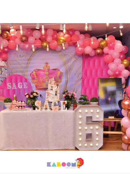 A royal party for a little queen, featuring a giant crown, a light-up number '6', and a beautiful pink and gold color scheme.